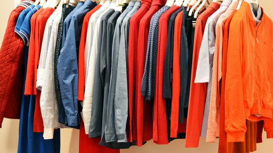 Rail Clothing. A selection of bright coloured clothes haging along a rail.