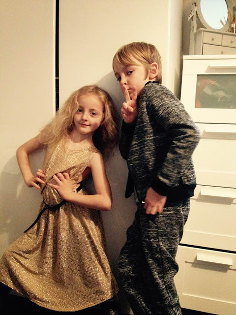 George and Molly. Molly dressed in a gold dress and George dressed in a full on matching grey outfit.